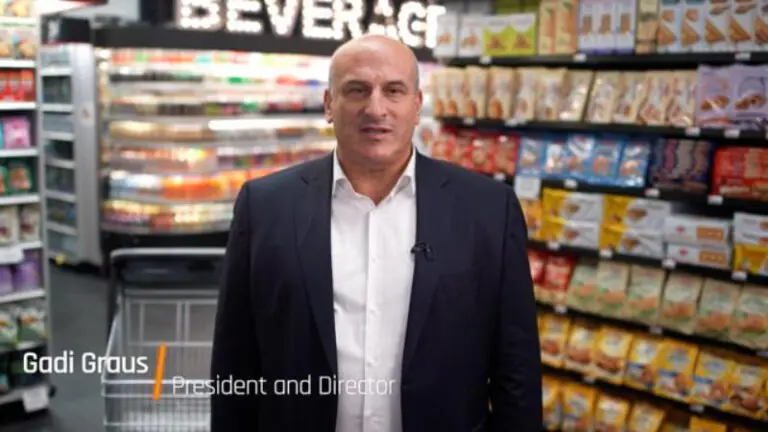 Man in supermarket aisle with products.